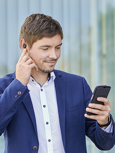 Business man makes phone calls via wireless headphones "Passion Chop" and his smartphone