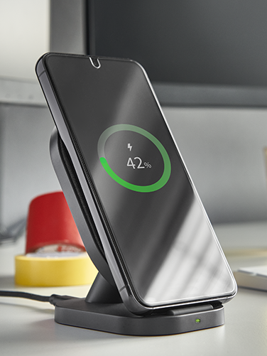 Smartphone is charged on wireless charger.