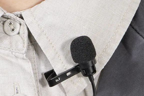 Clip-on microphone is clipped to the shirt collar.